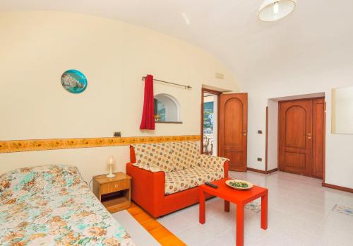 un soggiorno con divano rosso e tavolo di Villa Mare ad Amalfi
