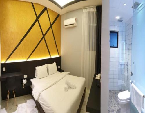 a bedroom with a white bed and a bathroom at Suite Dreamz Hotel Banting in Banting