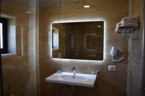 a bathroom with a sink and a mirror at Amber Hotel Albania in Spille