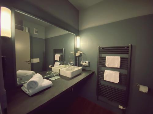 a bathroom with a sink and a large mirror at Hotel Am Schloss Ahrensburg in Ahrensburg