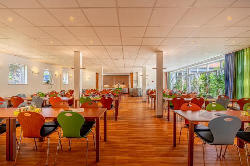 a dining room with tables and chairs and windows at Denkhaus Loccum in Rehburg-Loccum
