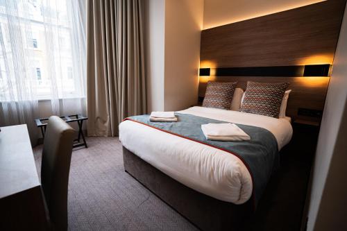 a hotel room with a large bed and a window at Oxford Hotel in London
