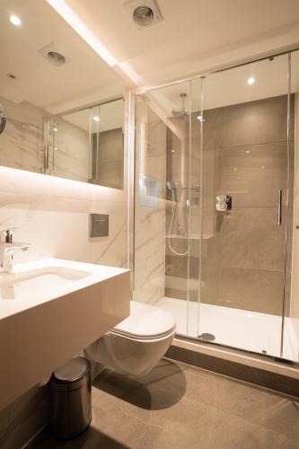 a bathroom with a shower and a toilet and a sink at Oxford Hotel in London