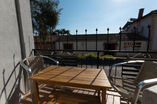 a wooden table and chairs on a balcony at Rebetika Hotel & bistro in Selcuk