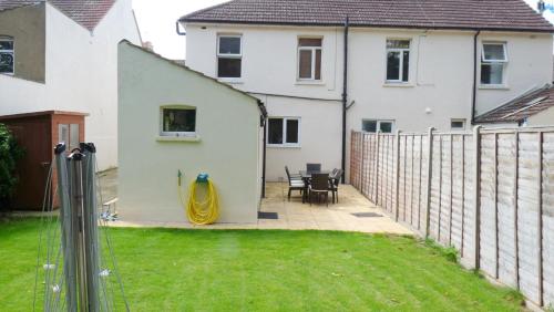 a backyard with a fence and a house at Bassett House with 3 bedrooms, fast Wi-Fi and off road parking in Kent