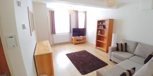 a living room with a couch and a tv at Bassett House with 3 bedrooms, fast Wi-Fi and off road parking in Kent