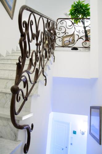 a wrought iron railing in a staircase with a plant at Palazzo Marzoli charme Resort - Small Luxury Hotel in Positano
