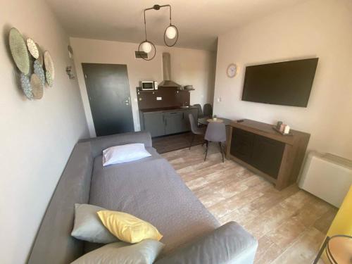 a living room with a couch and a flat screen tv at Balkon Apartmanház Panzió in Balatonfüred