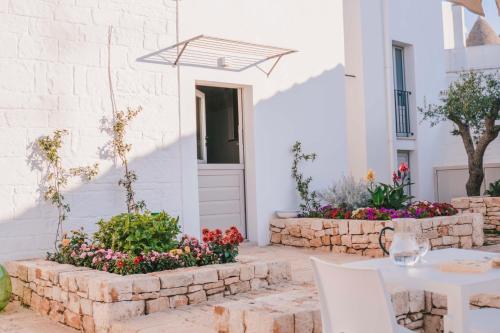 a patio with a table and flowers in front of a building at Trulli in corte in Alberobello