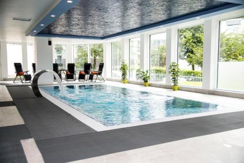 a large pool with a water slide in a building at Hotel Villa Elsa in Bad Kissingen