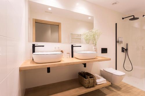 a bathroom with two sinks and a toilet at Getaria Apartamentuak - Balentziaga in Getaria