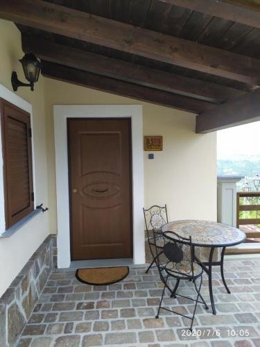 a patio with a table and a brown door at I fiori del Pollino - Guest House in San Severino Lucano