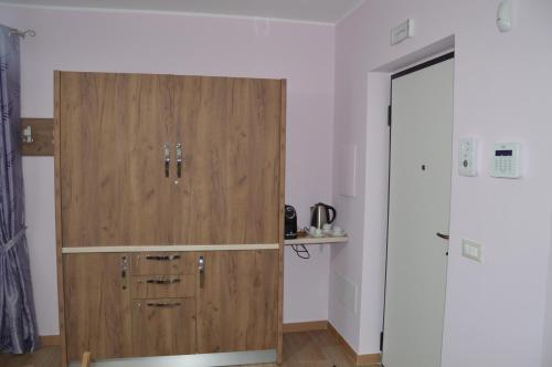 a large wooden cabinet in a room with a door at I fiori del Pollino - Guest House in San Severino Lucano