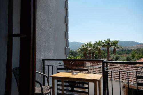 una mesa en un balcón con vistas a las montañas en Rebetika Hotel & bistro, en Selçuk