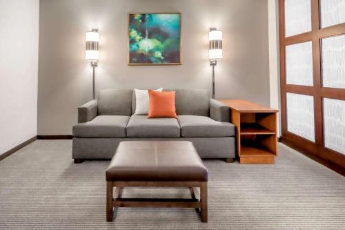 a living room with a couch and a table at Hyatt Place Salt Lake City Airport in Salt Lake City