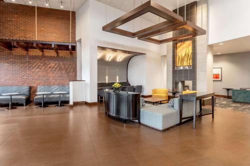 a lobby with chairs and tables in a building at Hyatt Place Salt Lake City Airport in Salt Lake City