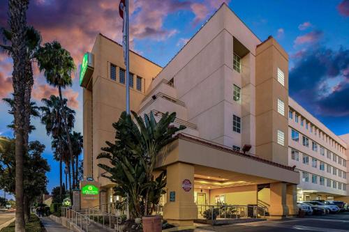 a hotel building with a palm tree in front of it at La Quinta by Wyndham Anaheim in Anaheim