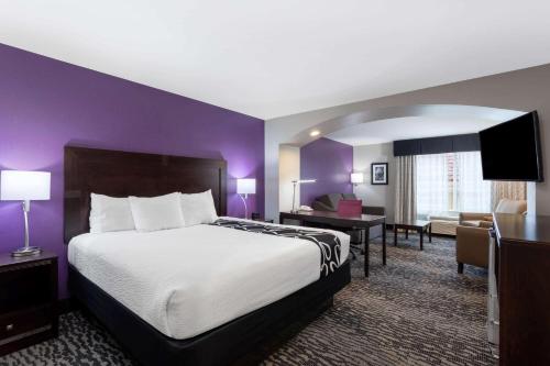 a hotel room with a large bed and a desk at La Quinta by Wyndham Huntsville Airport Madison in Madison