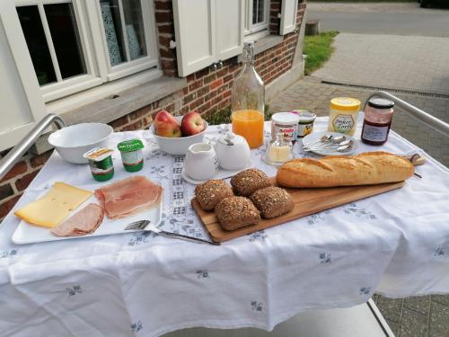 B&B Leybeeckhof في Holsbeek: طاولة مع افطار من خبز ولحم وجبن