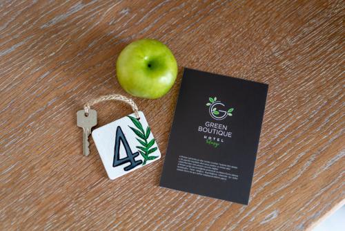 a green apple on a table with a tag and a key at Green Boutique Selimiye in Selimiye