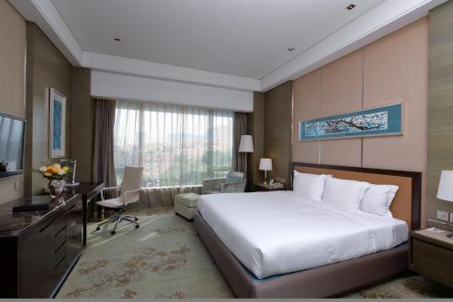 a hotel room with a large bed and a desk at Crowne Plaza Nanjing Jiangning by IHG in Nanjing