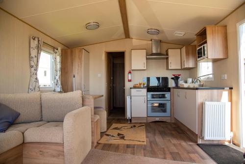 eine kleine Küche und ein Wohnzimmer in einem Wohnwagen in der Unterkunft Devon Cliffs Holiday Home in Exmouth