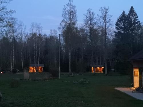 a house in the middle of a yard at night at Brīvdienu māja "Raudiņi" in Kaltene