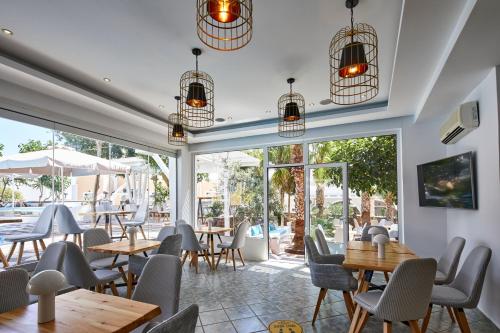 a restaurant with tables and chairs and a patio at Blue Sea Hotel in Kamari
