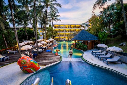 a pool at a resort with a person standing in the middle at Peach Hill Resort - SHA Extra Plus in Kata Beach