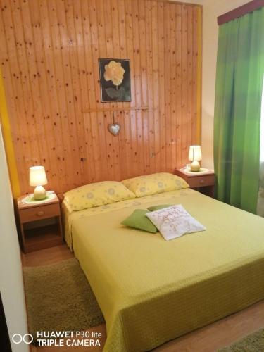 a bedroom with a bed and two tables with lamps at Apartmani Zute in Korčula