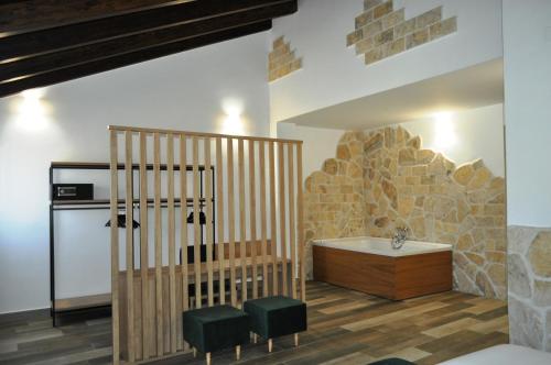 a bathroom with a tub in a room with a stone wall at Hostal Restaurante Villa de Brihuega in Brihuega