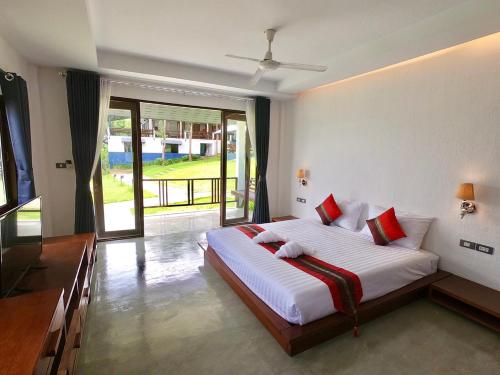 a bedroom with a large white bed with red pillows at Diamond Village Pai in Pai