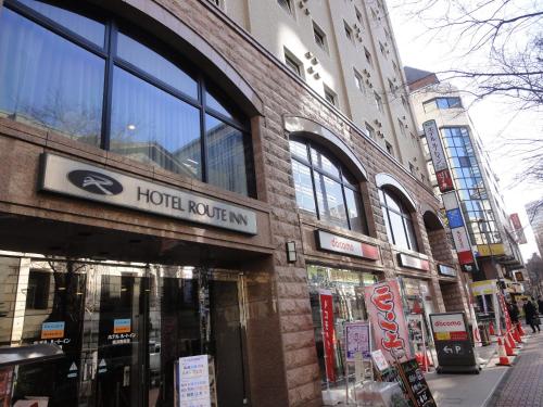 a building with a hotel revival sign on a city street at Hotel Route-Inn Yokohama Bashamichi in Yokohama