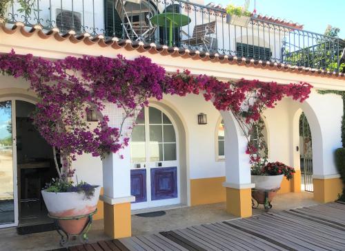 a building with flowers hanging from it at O Pátio in Fernao Ferro