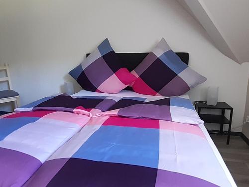 a bed with a colorful blanket and pillows on it at Ferienhaus Maag in Attendorn