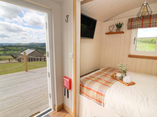 a bedroom with a bed and a sliding glass door at Marches Way in Rhayader
