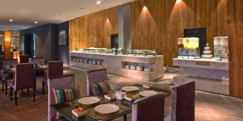 un restaurante con mesa, sillas y barra en Avana Laem Chabang Boutique Hotel en Ban Laem Chabang