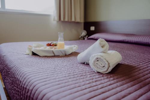 a hotel room with towels and a tray of food on a bed at Tocchi di Puglia in Castellaneta Marina