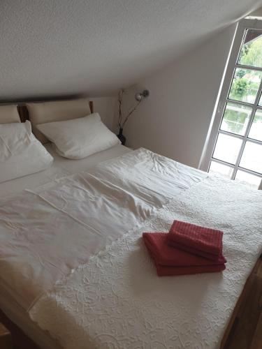 a white bed with a red box on it at Apartment am Stadtsee in Mölln