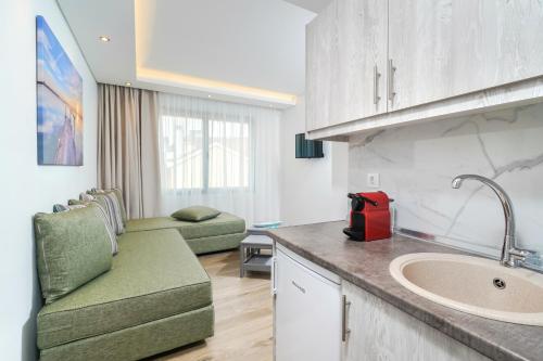 a kitchen with a sink and a living room at Maria Elena Suites in Limenas