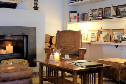 a living room with a table and a chair and a fireplace at El Far Hotel Restaurant in Llafranc