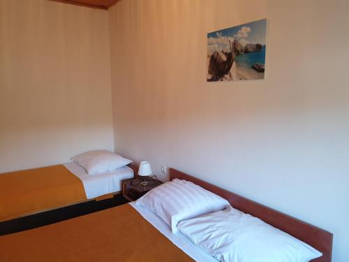 a bedroom with two beds and a painting on the wall at Apartmani Dalmatinka in Metajna