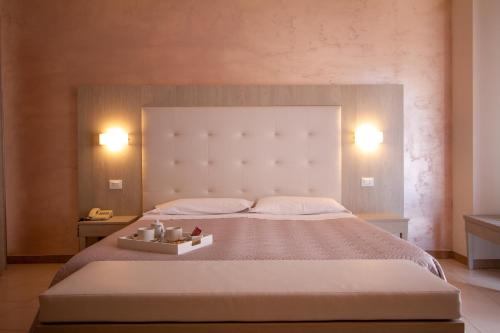 een slaapkamer met een groot bed met 2 verlichting bij Falcon Hotel in SantʼAgata Feltria