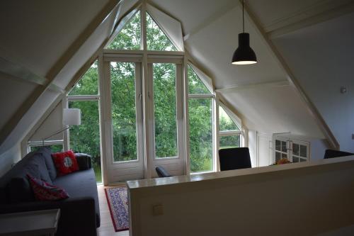a living room with large windows in an attic at BenBZuiderzee in Hattem