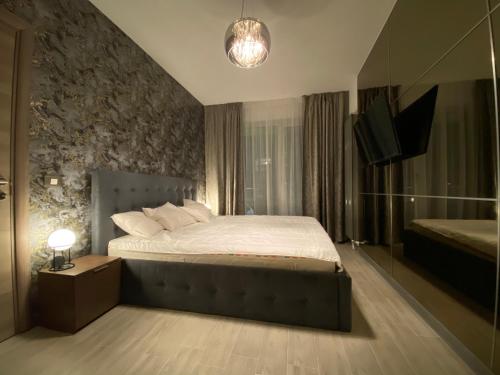 1 dormitorio con 1 cama y TV en Maya Luxury Alezzi Beach Resort, en Mamaia Nord – Năvodari