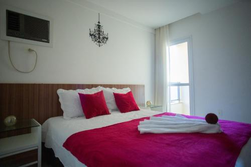 ein Schlafzimmer mit einem großen Bett mit einer roten Decke in der Unterkunft Suíte Guarapari - 3 quartos na Praia das Virtudes in Guarapari