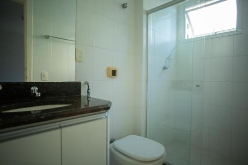 y baño con aseo, lavabo y ducha. en Suíte Guarapari - 3 quartos na Praia das Virtudes, en Guarapari