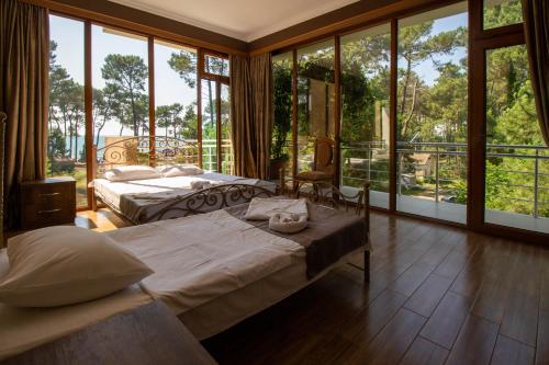 2 camas en una habitación con ventanas grandes en Hotel Inter en Ureki