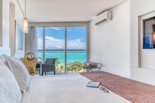 a bedroom with a bed with a view of the ocean at Hotel Brisa Praia Pajuçara in Maceió