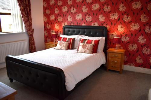 a bedroom with a large bed with red walls at The Meadows B&B in Moville